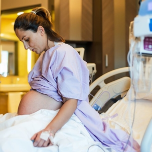Pregnant woman sitting on a hospital bed