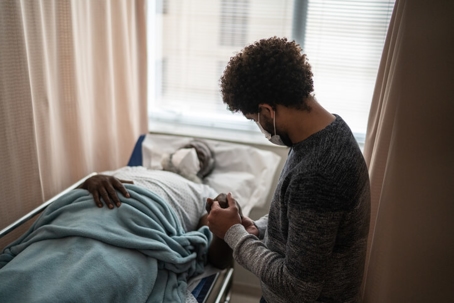 young man with sick father in hospital