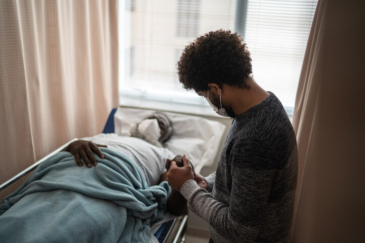 young man with sick father in hospital